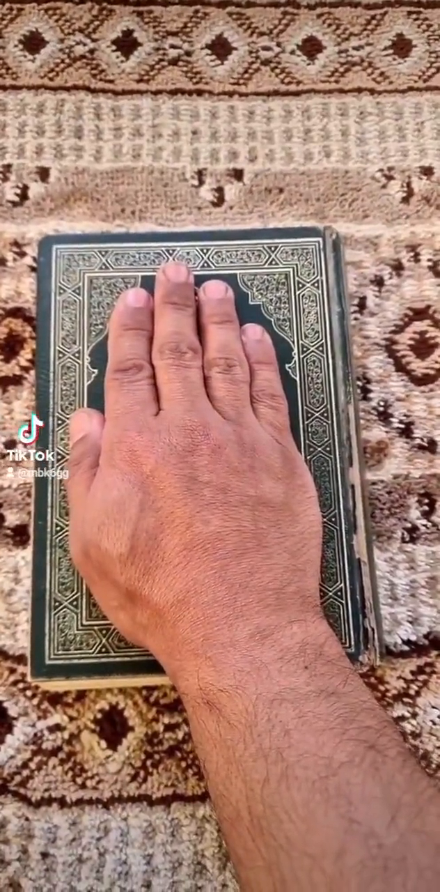 رجل يقسم ويحلف على القرآن بأن