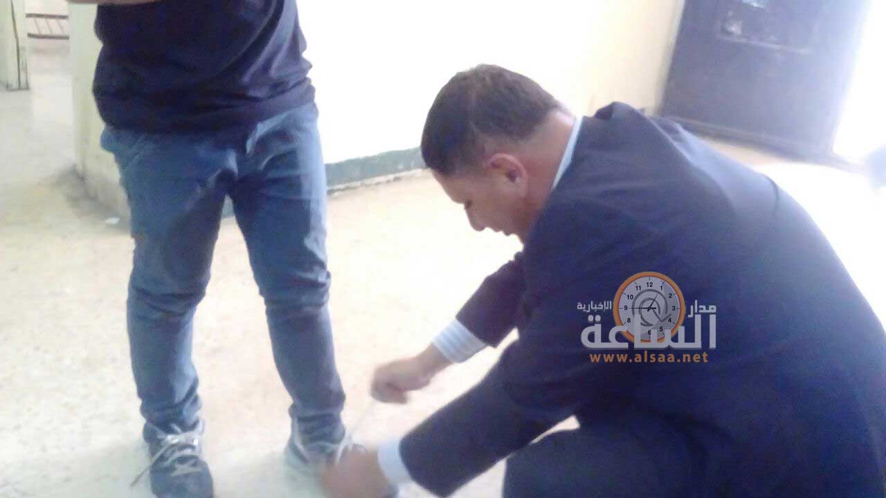 معلم في مأدبا ينحني لربط حذاء