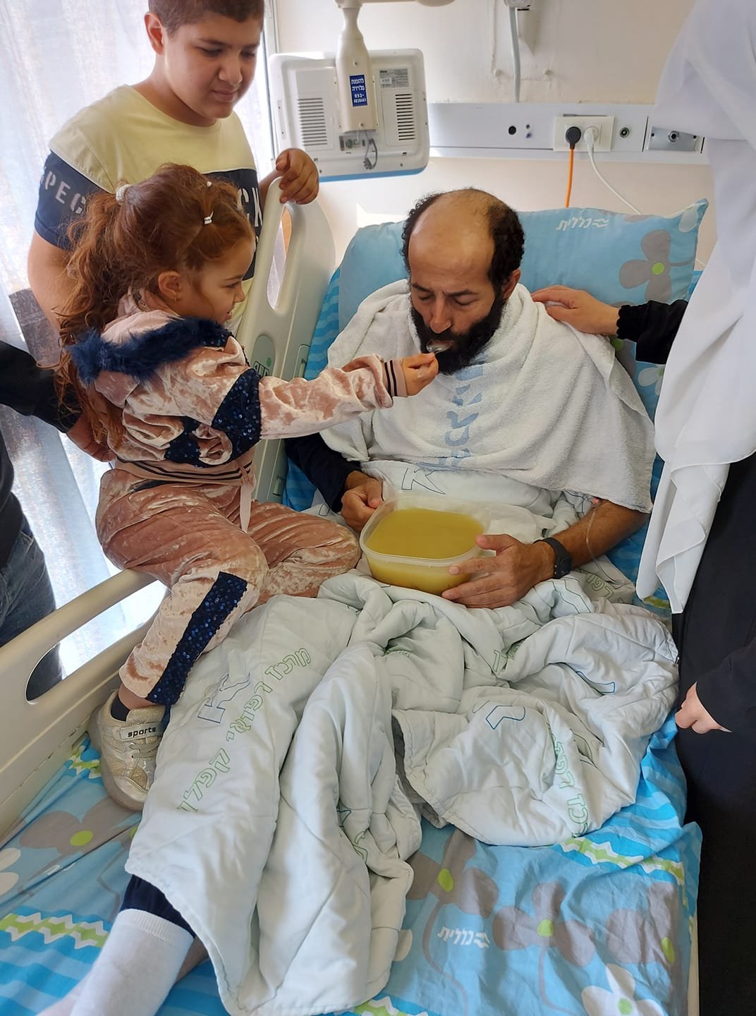 صورة الطفلة الفلسطينية وهي تطعم والدها