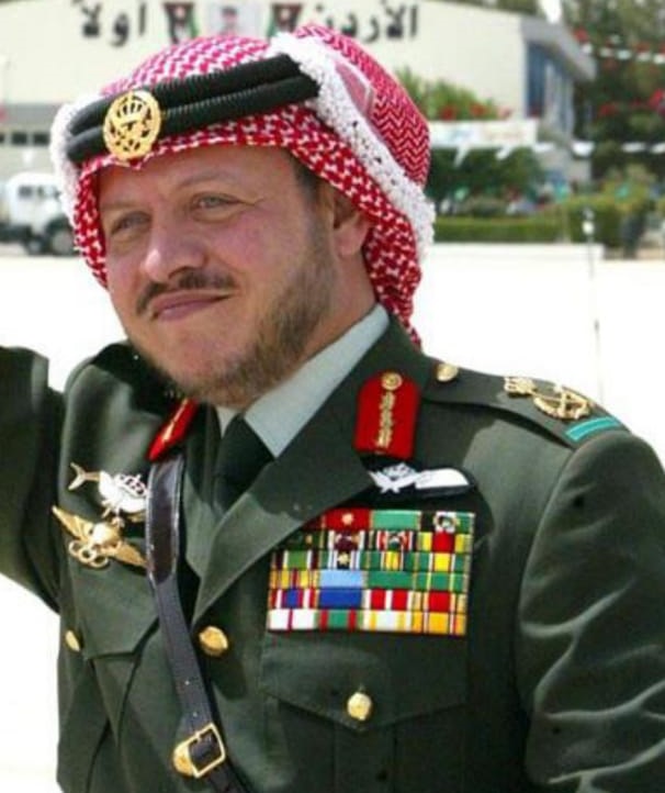 الملك يضع الشارة الخضراء على كتفه