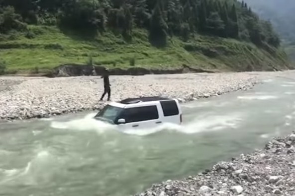 شاهد .. يخوض بسيارته مياه نهر