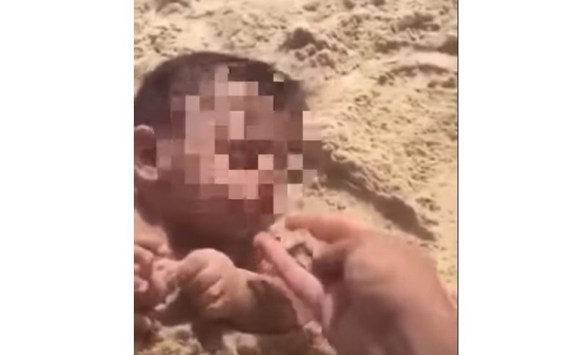 رجل يطعم رضيعا الرمل (فيديو)